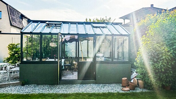 A glass greenhouse structure with a door, a table, and chairs inside. - 3 bedroom lovely home in Ystad (Ystad)