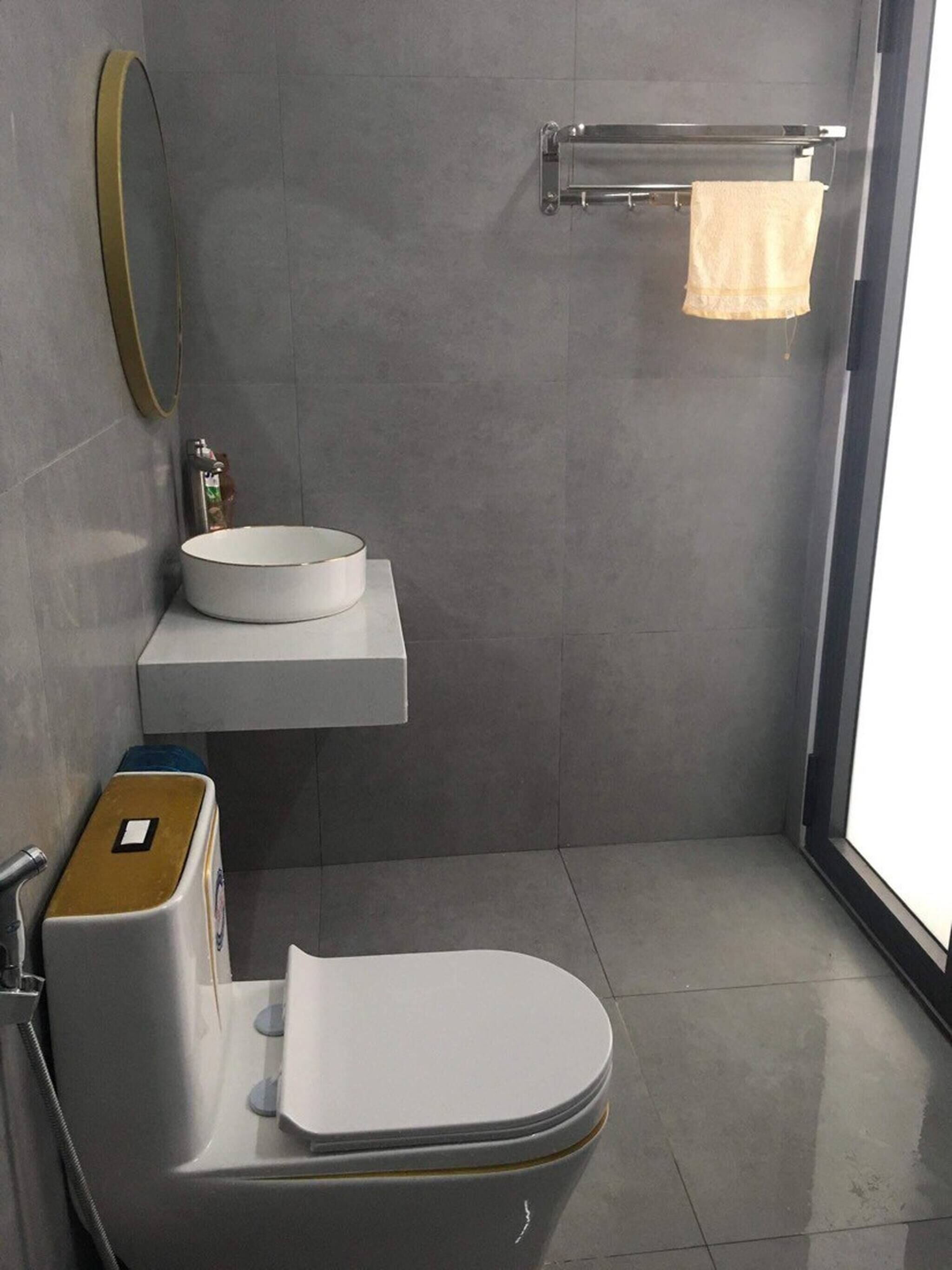 Un baño moderno con inodoro, lavabo y espejo.