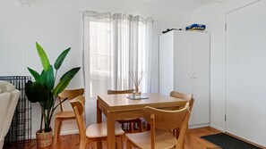 Cozy retreat with a dining table for four, a wardrobe, and a potted plant.