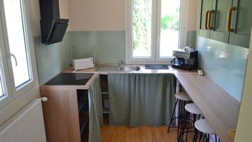 A compact kitchen with a built-in stove, a sink, and a window providing natural light.