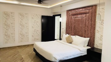 Un dormitorio moderno con una cama grande, paredes con estampado de mármol y un cabecero texturizado único.
