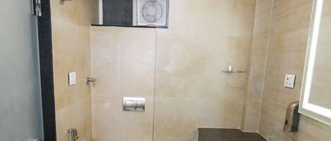 A modern bathroom with a glass-enclosed shower, a white toilet, and a marble countertop with a sink.