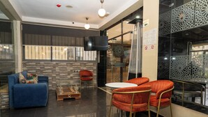 Una sala de estar moderna con un sofá azul, un sillón rojo y una pequeña mesa.