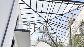 A modern building with a glass atrium, multiple floors, and a staircase. - Malibu Village (Canet-en-Roussillon)