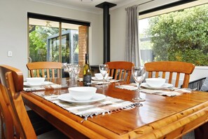 Enjoy meals with a view of lush greenery from this dining area, featuring a table set for four and a brick column.