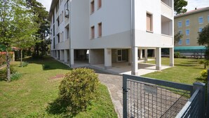 En flervåningsbostadsbyggnad med ett platt tak, stora fönster och en ingång som är skyddad av ett tak.