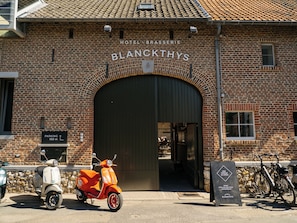 A brick building with a large arched entrance labeled 'Blanckthys' and a sign indicating parking 150 meters away. - Blanckthys Hotel Voeren - digital check-in, key by email or SMS (Voeren)