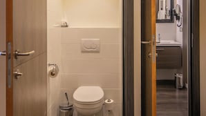 A modern bathroom with a toilet, sink, and mirror. - Blanckthys Hotel (Voeren)