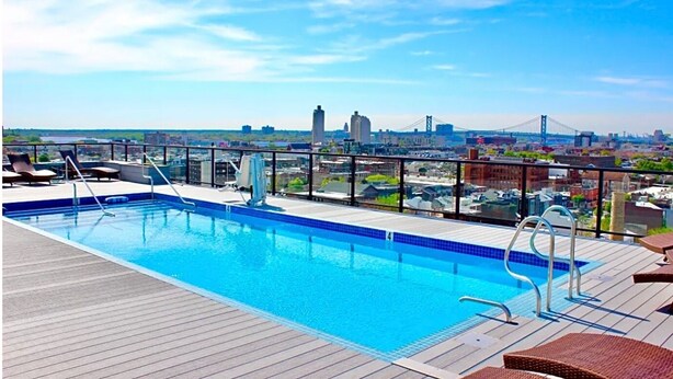 A rooftop pool with a city view, including a bridge and buildings. - XL Studio - Metro Studio, Chic Stay (Philadelphia)