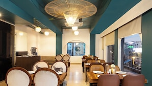 A restaurant with a long dining area, wooden tables, and chairs. - Skon Boutique by Orion Hotels (New Delhi)