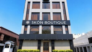 Un edificio moderno con un letrero que dice 'SKÖN BOUTIQUE'.