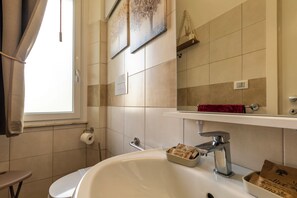 A bathroom with a white sink, a mirror, a towel rack, and a window. - Urban Beach (Francavilla al Mare)