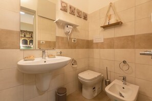 A bathroom with a sink, toilet, bidet, and a mirror. - Urban Beach (Francavilla al Mare)
