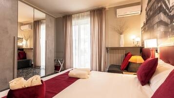 Camera d'albergo con un letto grande, uno specchio, un termosifone e vista su un edificio dalla finestra.