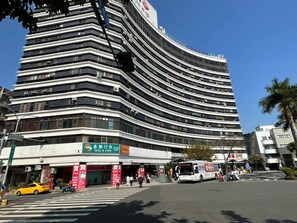 A modern hotel with a curved facade, multiple floors, and a prominent sign for the Gala Inn. - GALA INN (Tainan)