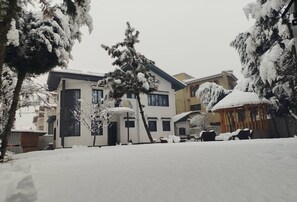 A snow-covered residential area with houses, a gazebo, and a tree. - Dilan Residency Villa -5 Bedroom- Centrally Heated (Srinagar)