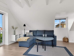A modern living room with a sectional sofa, a round coffee table, and a floor lamp.