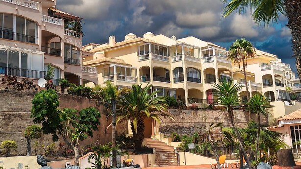 A resort with a swimming pool, palm trees, and multi-story buildings with balconies. - Casa Palmu apartment - A peaceful and relaxing oasis in Golf del Sur, Tenerife (Golf del Sur)
