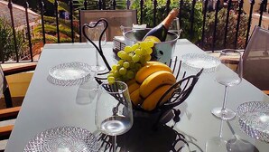 A dining table set outdoors with a clear view of a residential area in the background. - Casa Palmu apartment - A peaceful and relaxing oasis in Golf del Sur, Tenerife (Golf del Sur)