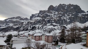 Eine verschneite Bergstadt mit Gebäuden und einem markanten Berg im Hintergrund.