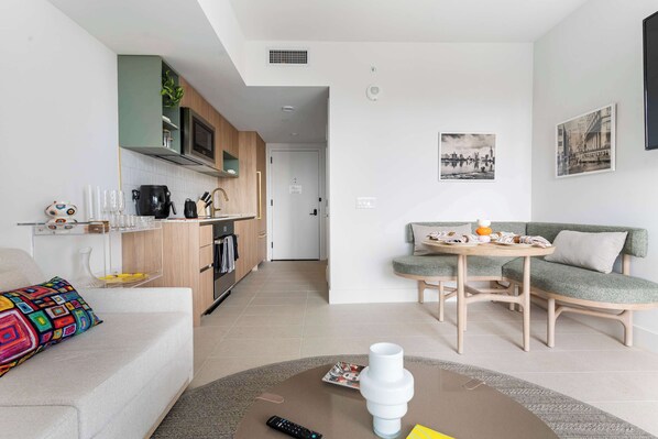 A modern living space with a kitchen, dining area, and seating.
