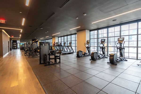 A gym with cardio machines, weight equipment, and large windows. - RumRunner, Downtown, Pool, Gym, Full Service Tower (Miami)