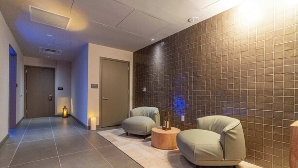 A hallway with two sofas, a wooden table, and a tiled wall. - RumRunner, Downtown, Pool, Gym, Full Service Tower (Miami)