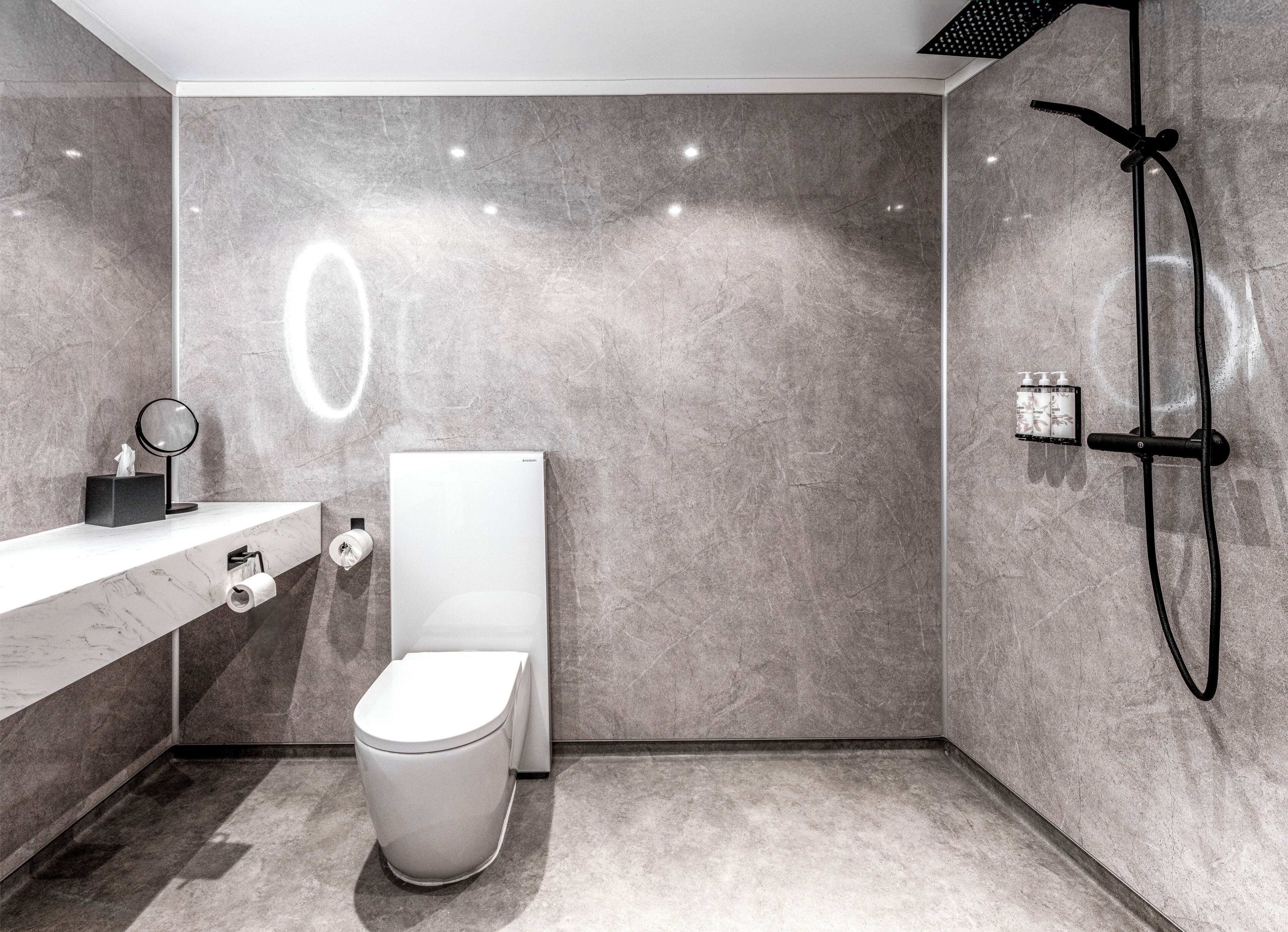 Ein modernes Badezimmer mit Toilette, Waschbecken und Dusche.