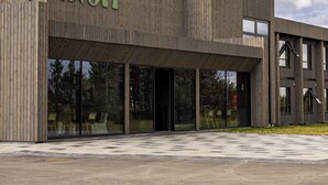 A modern hotel building with a wooden facade and large glass windows. - Hotel Loa (Rangárþing eystra)