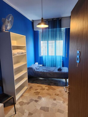 Ein kleines Zimmer mit einem Bett, einem Schrank und einem kleinen Tisch.