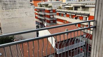 Un balcone con pavimento in piastrelle e ringhiera in metallo.