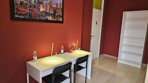 A room with a white desk and two black chairs, a framed picture of London on the wall, and a white shelving unit. - Guesthouse - Metro M1 Sesto Rondò (Sesto San Giovanni)