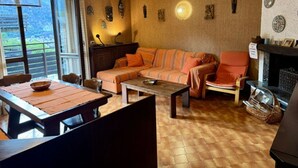 A living room with a sofa, armchairs, a coffee table, and a fireplace. - Vacation House Caspoggio.Apartment near local places of interest (Caspoggio)