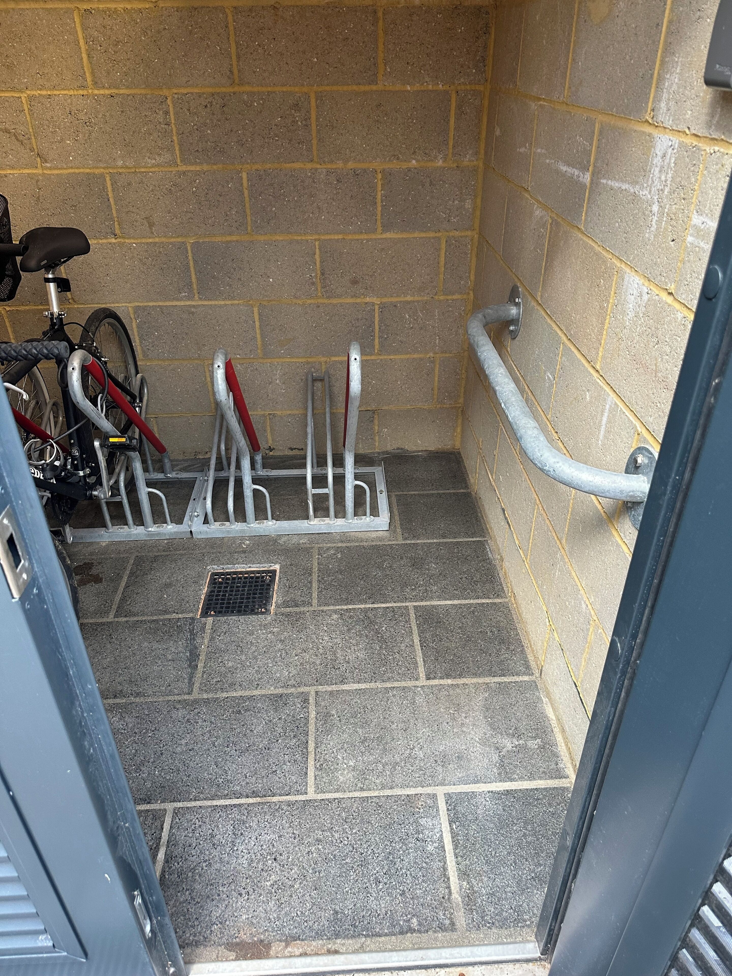 Et cykelparkeringsområde med cykelstativ og gelænder.