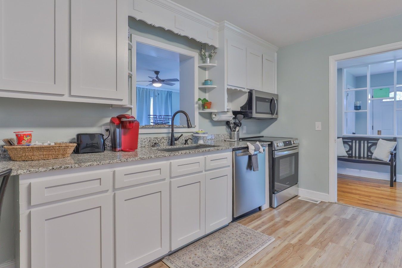 A kitchen with white cabinets, a microwave, a stove, and a dishwasher.