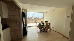 Eine moderne Küche mit Essbereich, großen Fenstern und Blick auf die Stadtlandschaft.