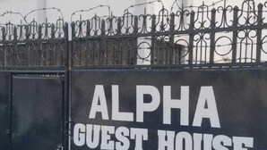 A black metal gate with the words "ALPHA GUEST HOUSE" in white letters. - ALPHA RETREAT (Kisumu)