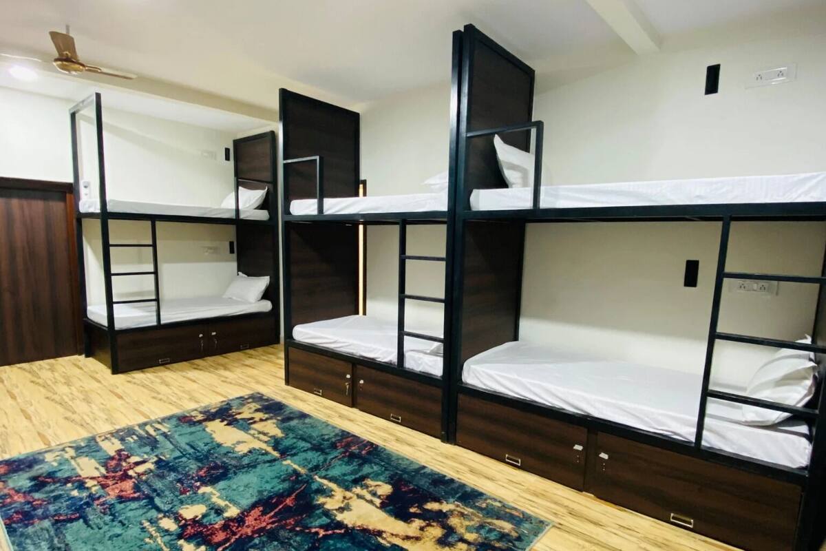 A room with bunk beds, a ceiling fan, and a patterned rug.