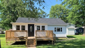 A small, single-story house with a front porch, a garage, and a covered outdoor area.