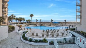 Un área de piscina con sillones de descanso y vista a la playa.