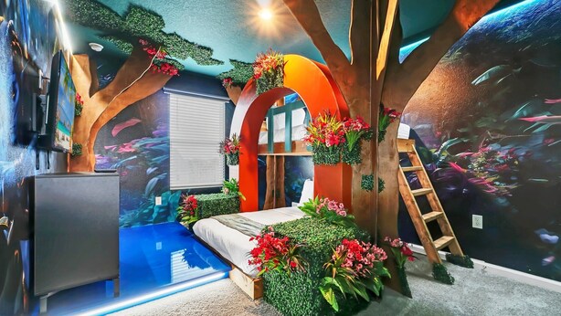A bedroom with a bed, a dresser, and a wall mural of an underwater scene. - Potter | Avatar | Mario Kart | Near Disney 2307 (Kissimmee)