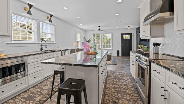 Una cocina moderna con una isla central, electrodomésticos de acero inoxidable y un piso con diseño.