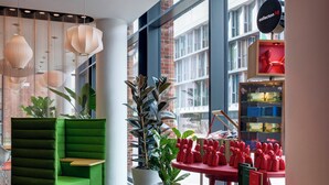 Un interno moderno con un divano verde, un tavolo in legno e una libreria rossa.