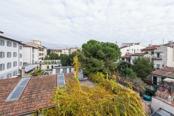 A residential area with multiple buildings, a large tree, and a rooftop with a skylight.