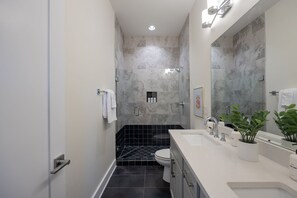 A modern bathroom with a shower, toilet, and sink. - The Pink Stetson: Rooftop Views, Party Hats, Games (Nashville)