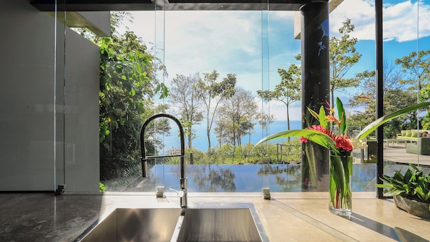 A modern bathroom with a large window, a sink, and a vase of flowers. - Casa Ceibo - Private Villa with Pool (Puntarenas Province)