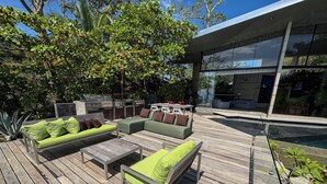A wooden deck with outdoor furniture, a barbecue area, and a pool. - Casa Ceibo - Private Villa with Pool (Puntarenas Province)