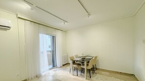 Un comedor con una mesa preparada para cuatro personas, una puerta corrediza de vidrio y un radiador.