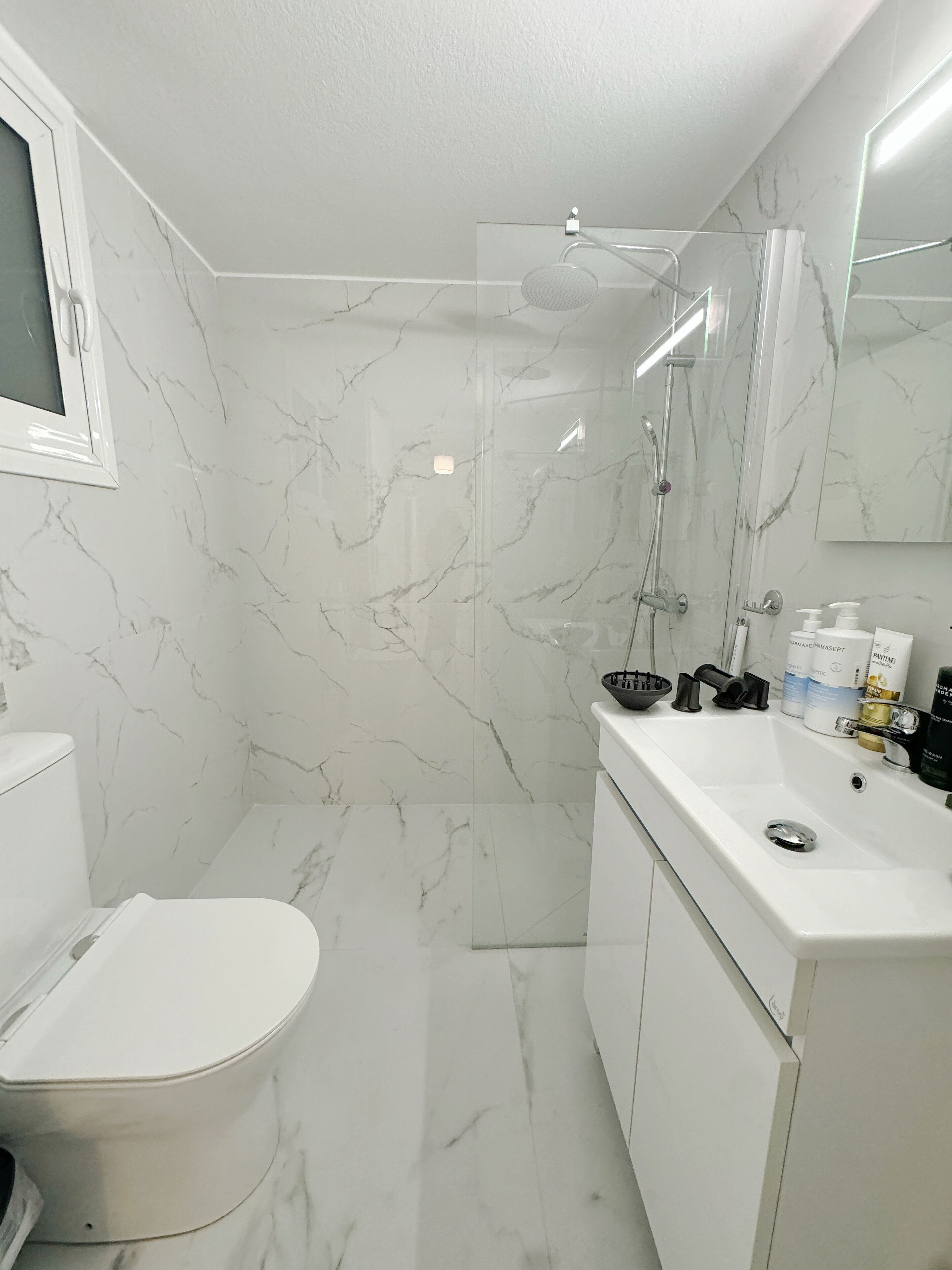 Ein modernes Badezimmer mit Toilette, Waschbecken und Dusche.