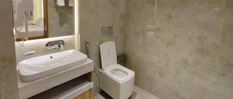Un baño moderno con un espejo grande, un lavabo y un inodoro.